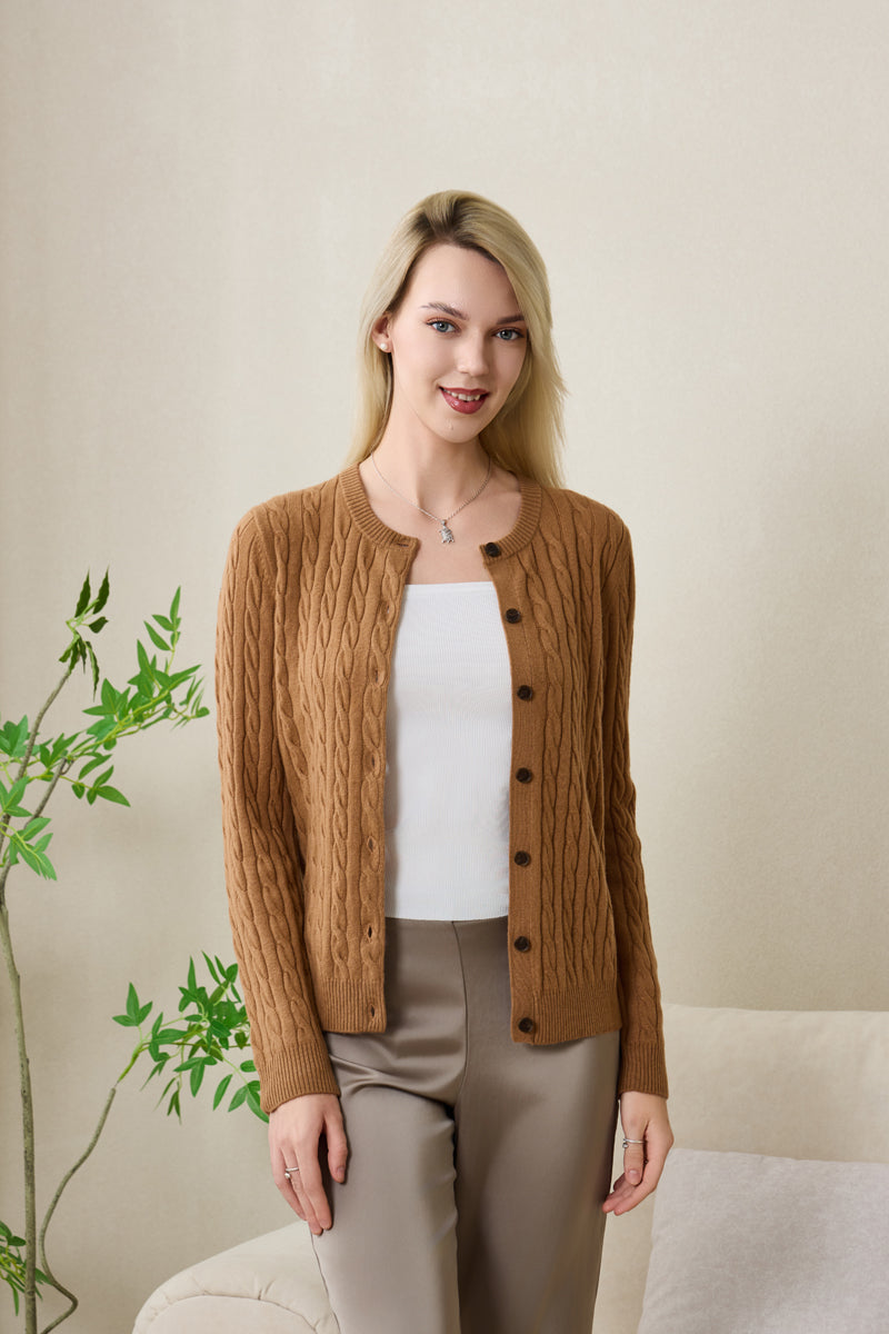 Woman wearing an Inis Aran cashmere medium camel cable cardigan#color_medium-camel