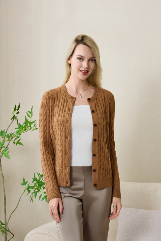 Woman wearing an Inis Aran cashmere medium camel cable cardigan#color_medium-camel