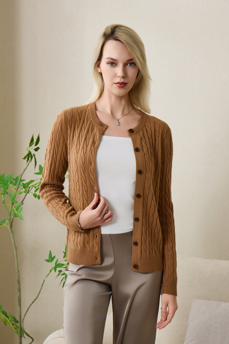 Woman wearing an Inis Aran cashmere medium camel cable cardigan#color_medium-camel