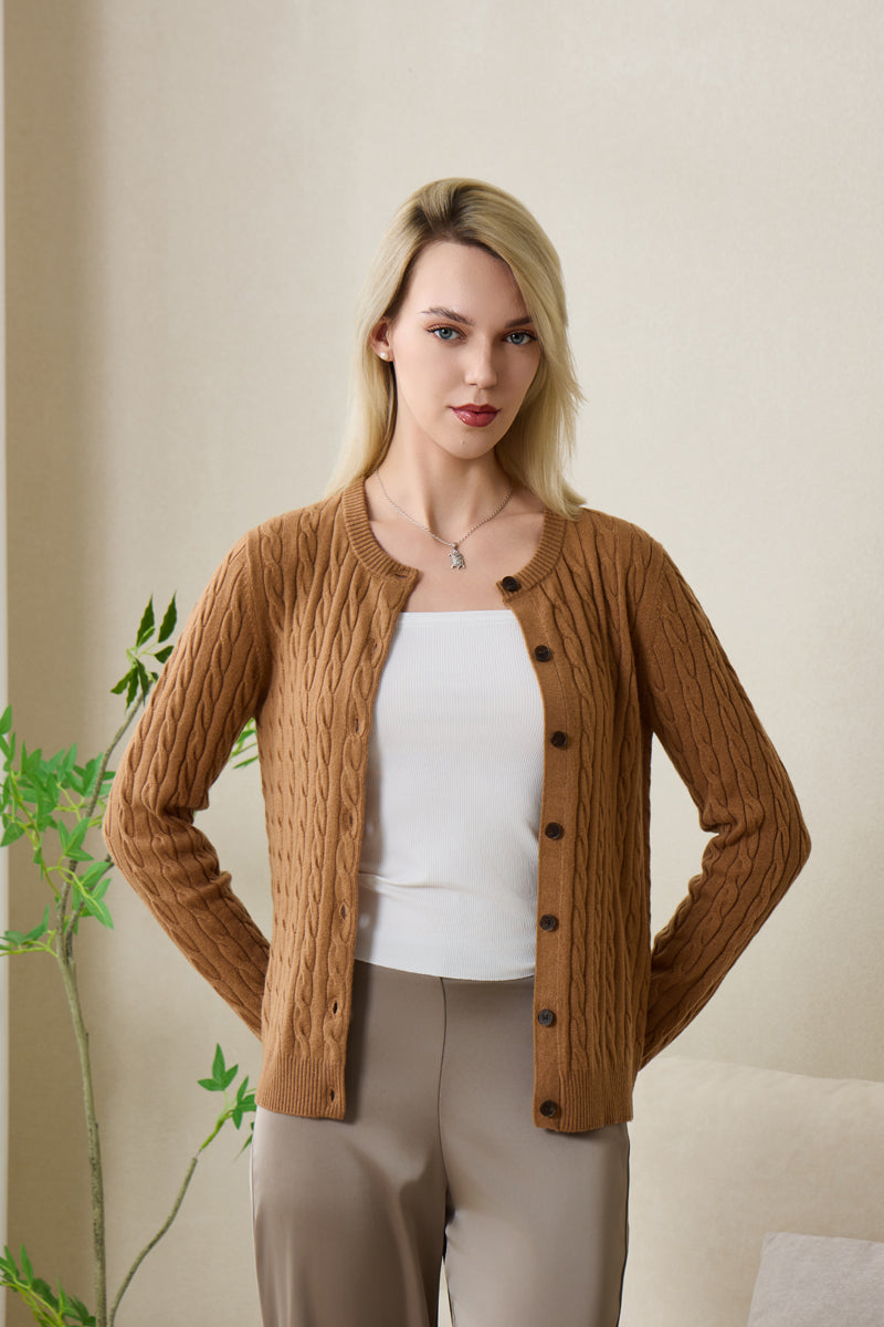 Woman wearing an Inis Aran cashmere medium camel cable cardigan#color_medium-camel