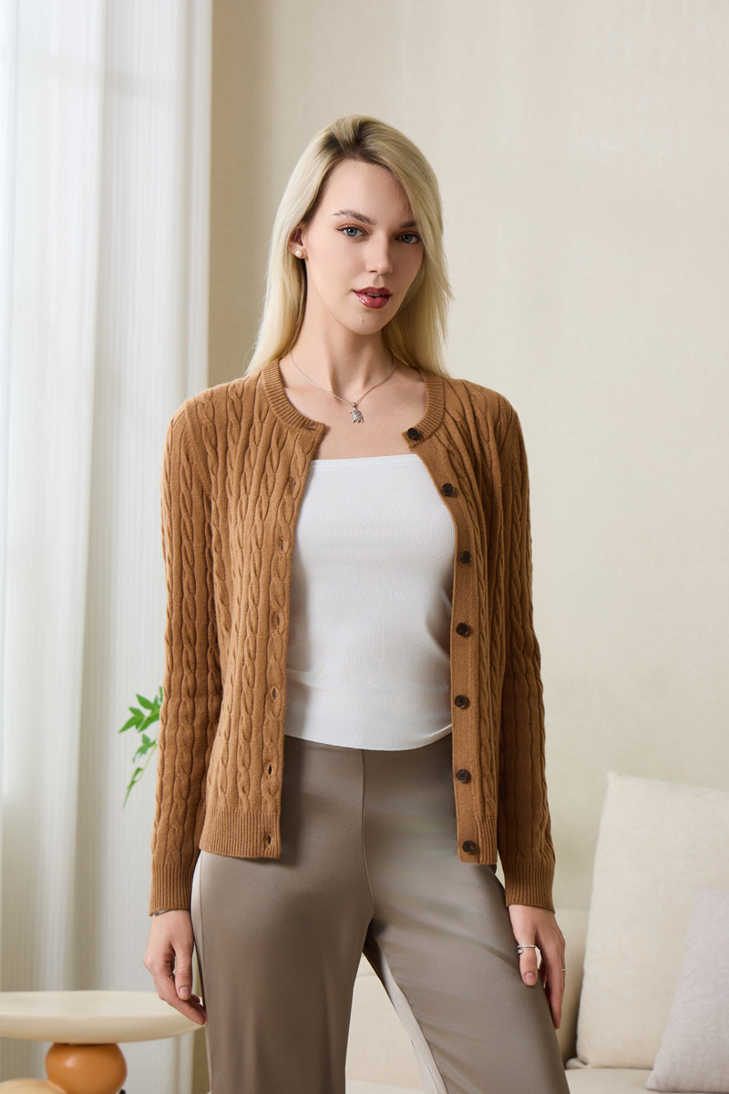 Woman wearing an Inis Aran cashmere medium camel cable cardigan#color_medium-camel