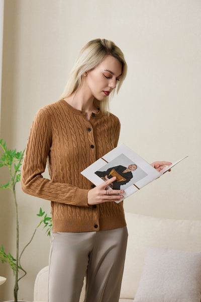 Woman wearing an Inis Aran cashmere medium camel cable cardigan#color_medium-camel