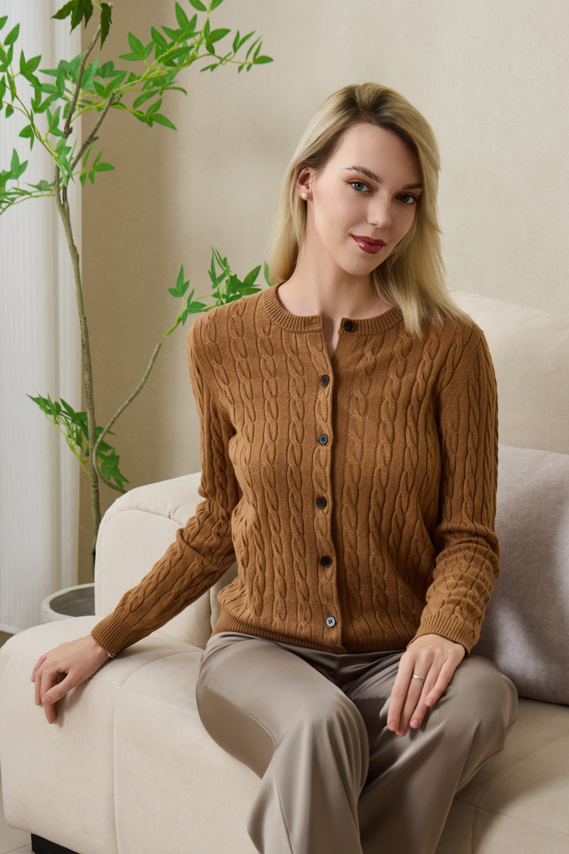 Woman wearing an Inis Aran cashmere medium camel cable cardigan#color_medium-camel