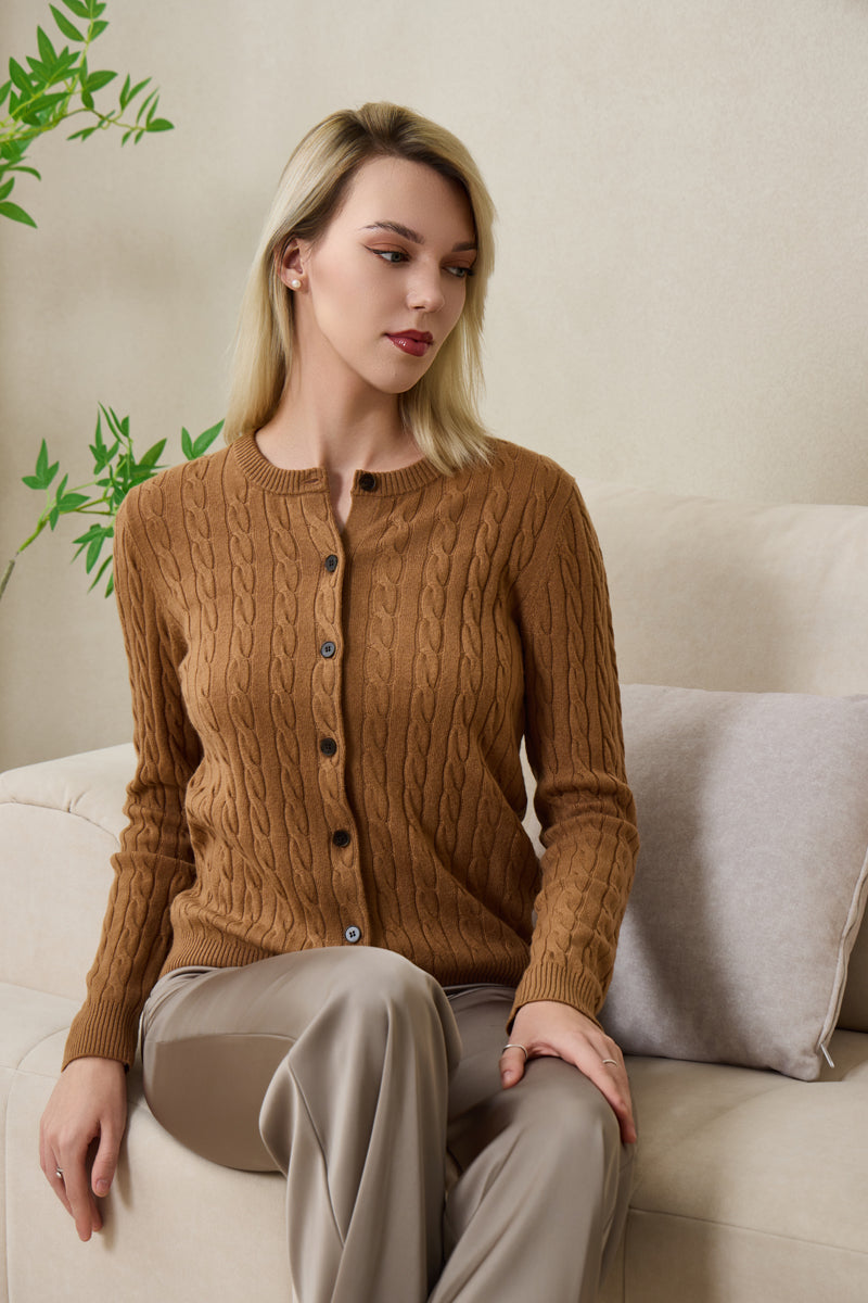 Woman wearing an Inis Aran cashmere medium camel cable cardigan#color_medium-camel