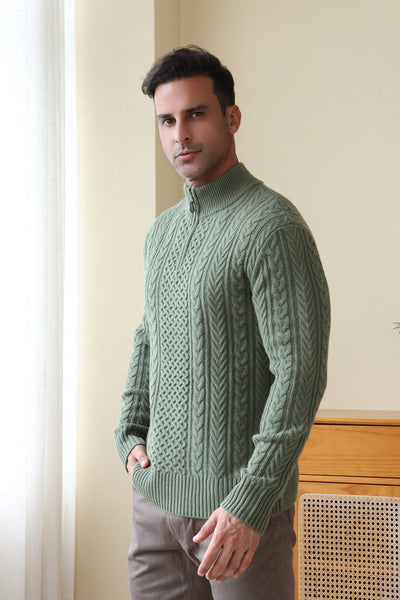 Man wearing a green Aran cable knit sweater by Inis Aran#color_boxwood