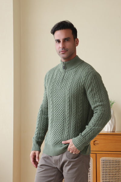 Man wearing a green Aran cable knit sweater by Inis Aran#color_boxwood